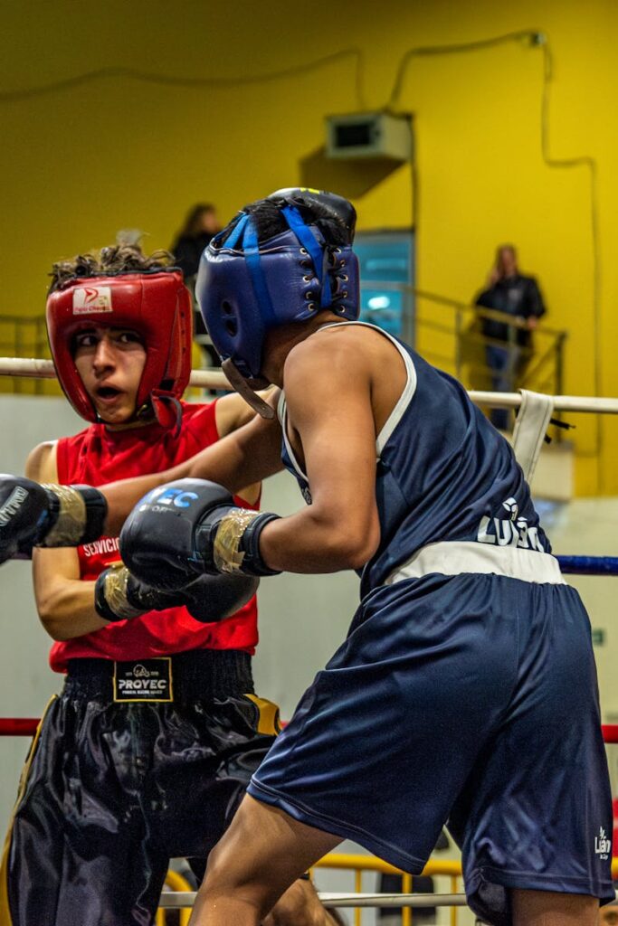 Two athletes engaged in a competitive boxing match, showcasing skill and determination.